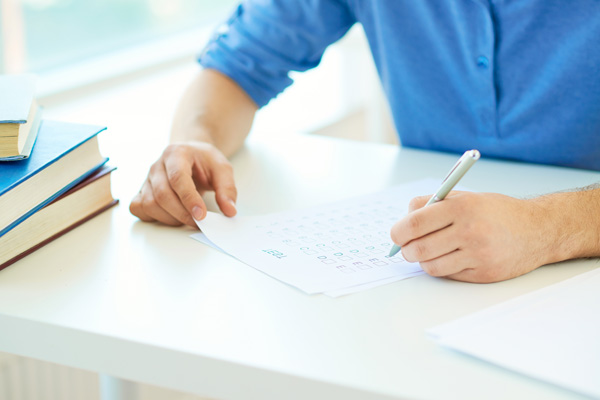 A man sitting at a white table filling out a moving checklist.